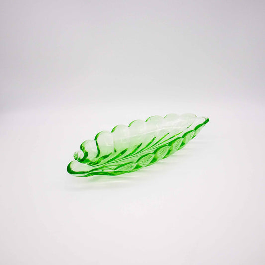 Grüne Schale aus Glas in Blattform, leicht schräg stehend