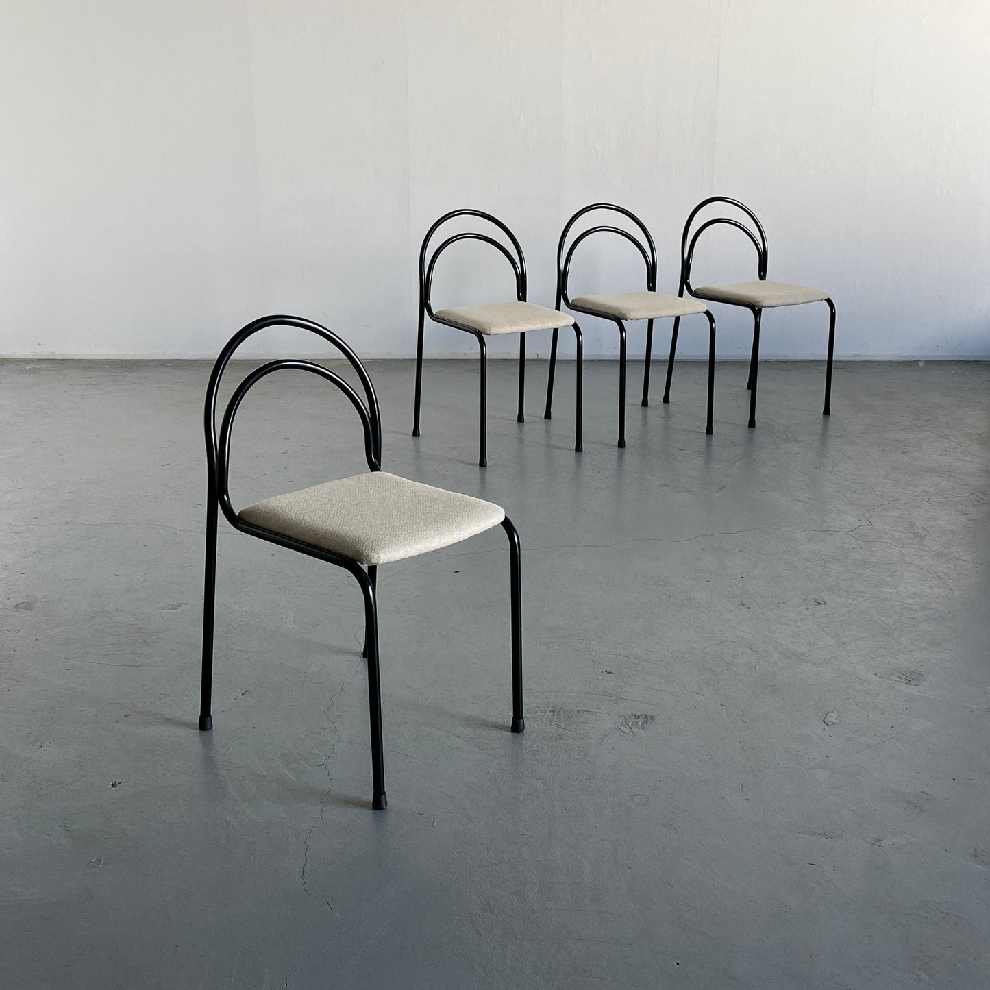 Set of 4 sculptural minimalist stackable dining chairs in curved iron frame and white wool upholstery, 1980s Italy vintage