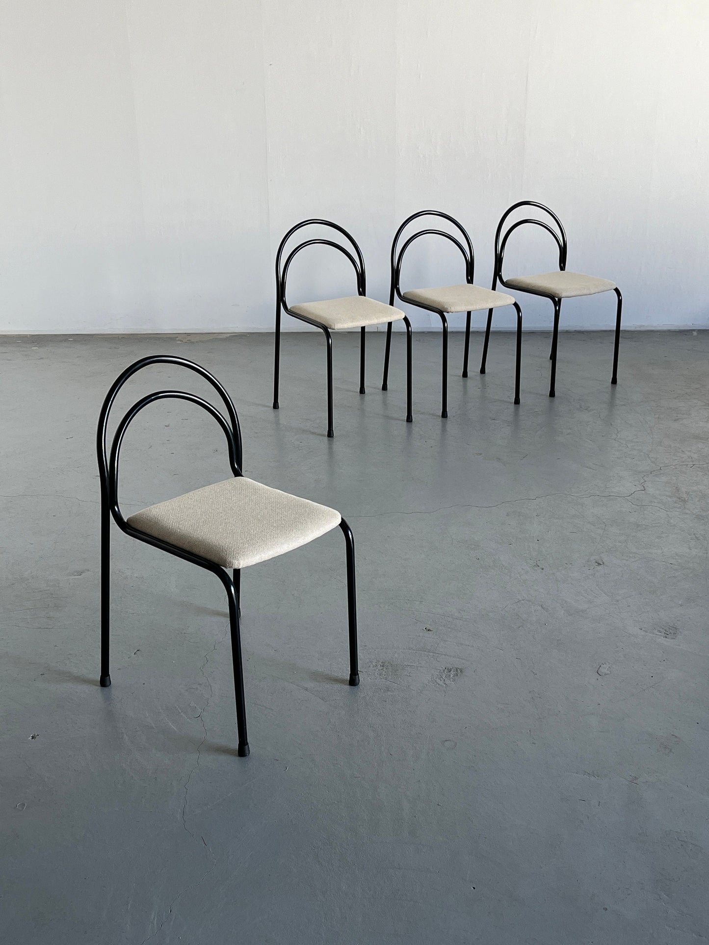 Set of 4 sculptural minimalist stackable dining chairs in curved iron frame and white wool upholstery, 1980s Italy vintage