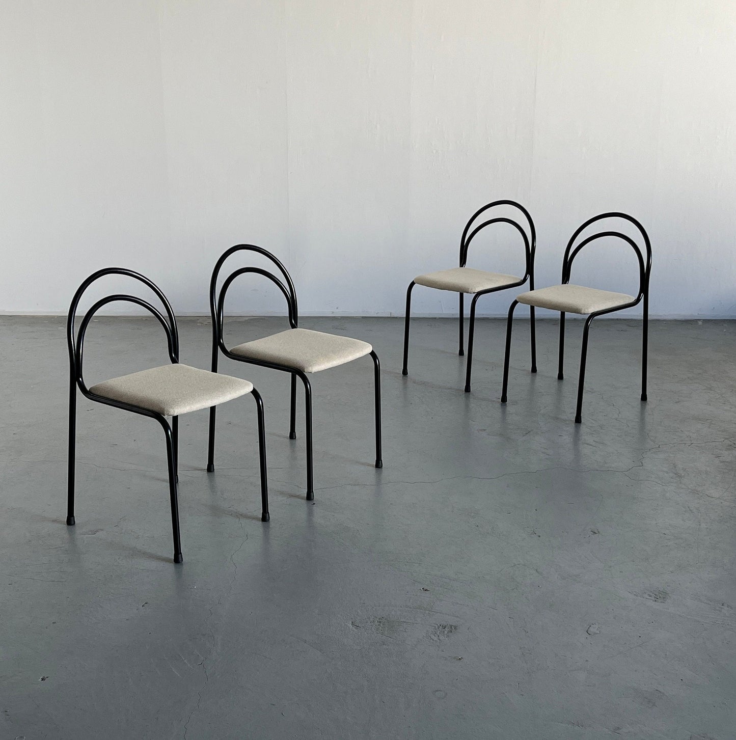 Set of 4 sculptural minimalist stackable dining chairs in curved iron frame and white wool upholstery, 1980s Italy vintage