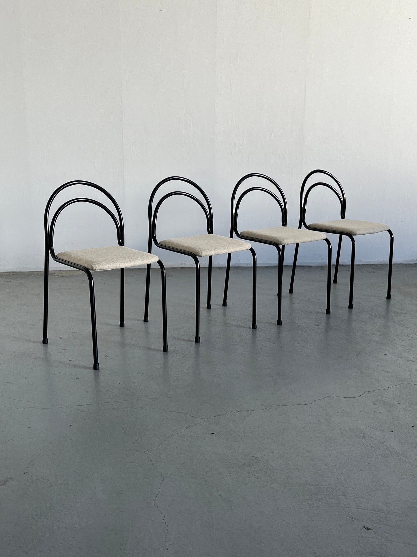 Set of 4 sculptural minimalist stackable dining chairs in curved iron frame and white wool upholstery, 1980s Italy vintage