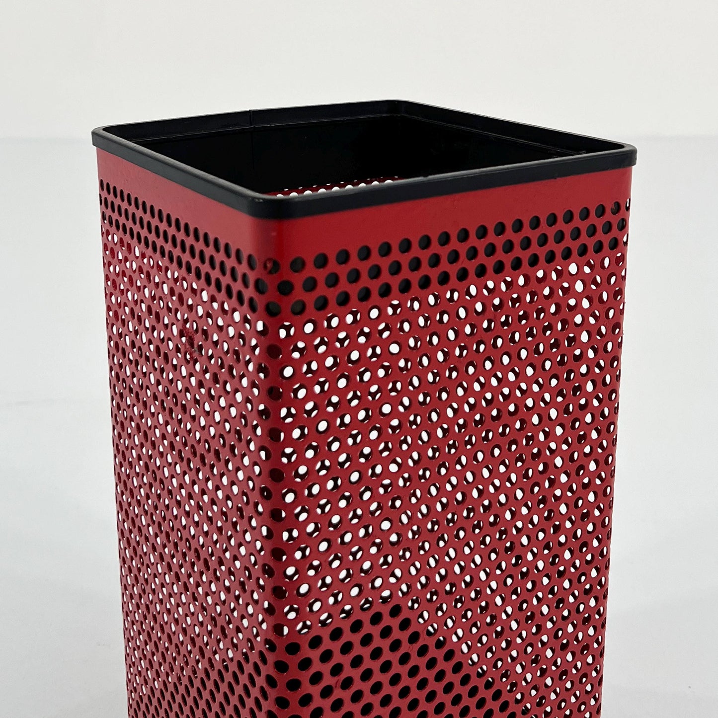 Red perforated trash can