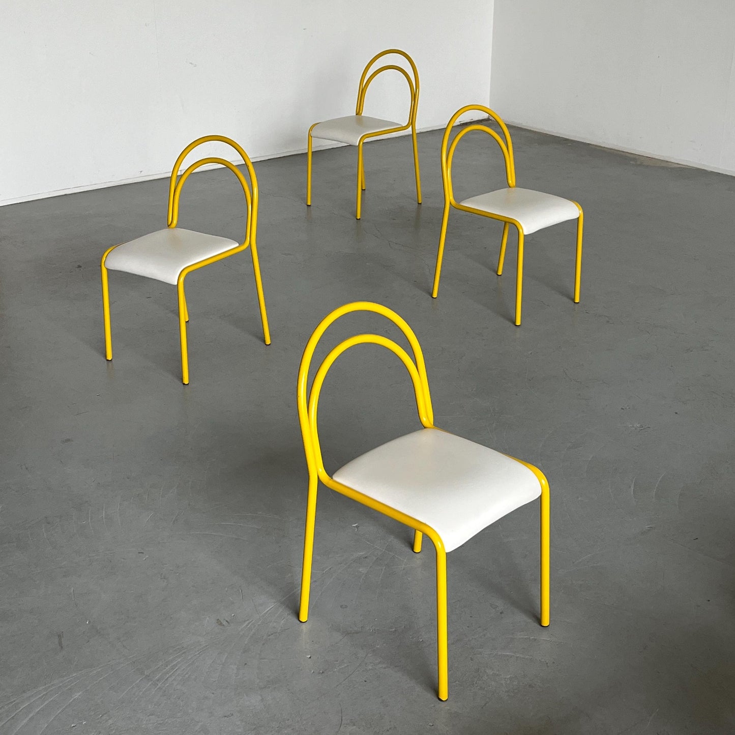 Ensemble de 4 chaises sculpturales avec structure en fer courbé jaune et revêtement en simili cuir blanc, Italie 1980