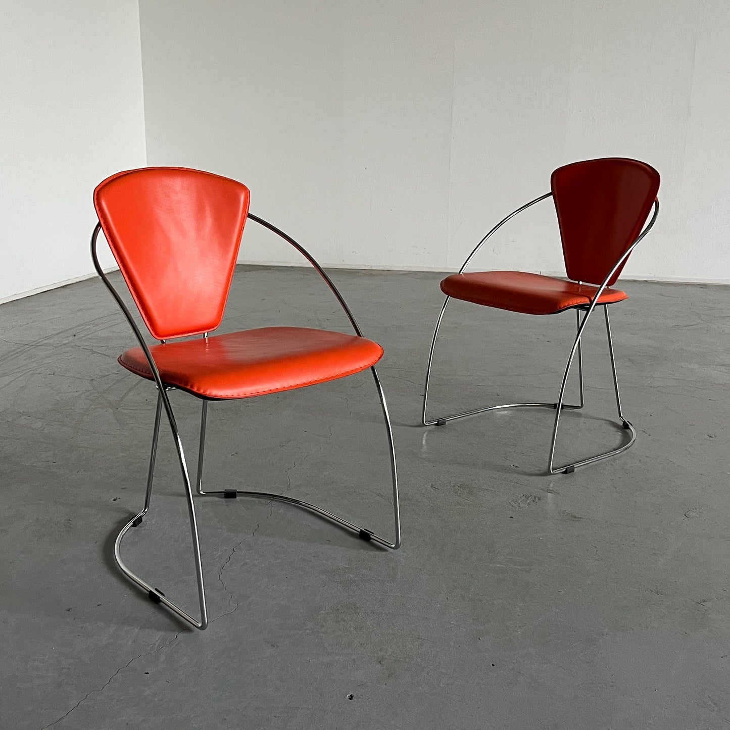 1 of 2 Postmodern orange dining chairs in the style of the Linda chair by Arrben, imitation leather and chromed steel, 1990s Italy