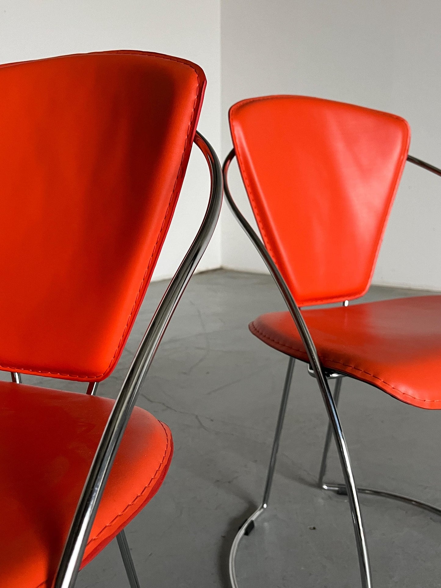 1 of 2 Postmodern orange dining chairs in the style of the Linda chair by Arrben, imitation leather and chromed steel, 1990s Italy