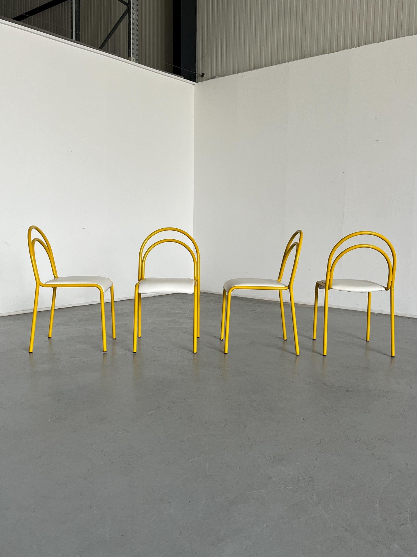 Ensemble de 4 chaises sculpturales avec structure en fer courbé jaune et revêtement en simili cuir blanc, Italie 1980