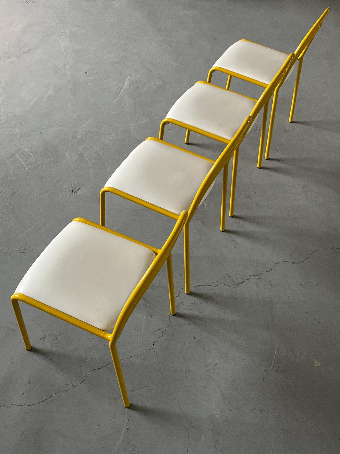 Ensemble de 4 chaises sculpturales avec structure en fer courbé jaune et revêtement en simili cuir blanc, Italie 1980